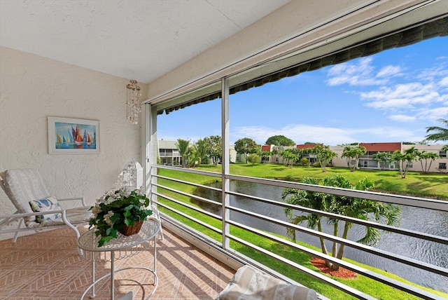 sunroom / solarium with a water view and a residential view