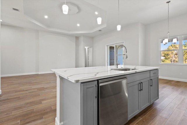 kitchen featuring gray cabinets, a raised ceiling, a sink, and dishwasher