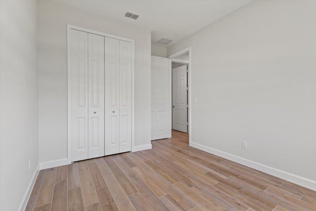 unfurnished bedroom with light wood-type flooring, visible vents, and baseboards