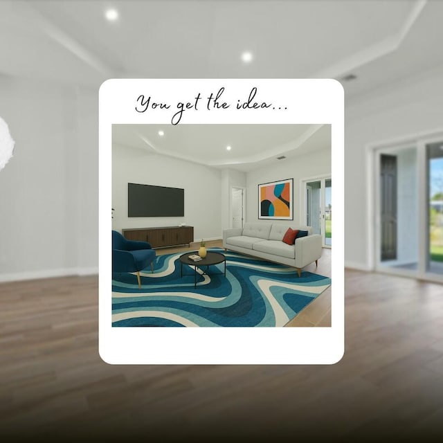 living room featuring baseboards, wood finished floors, a tray ceiling, and recessed lighting
