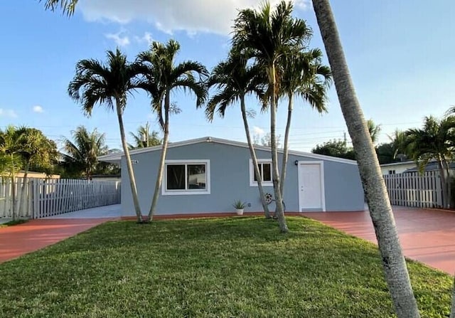 view of front of property with a front yard, fence, and stucco siding