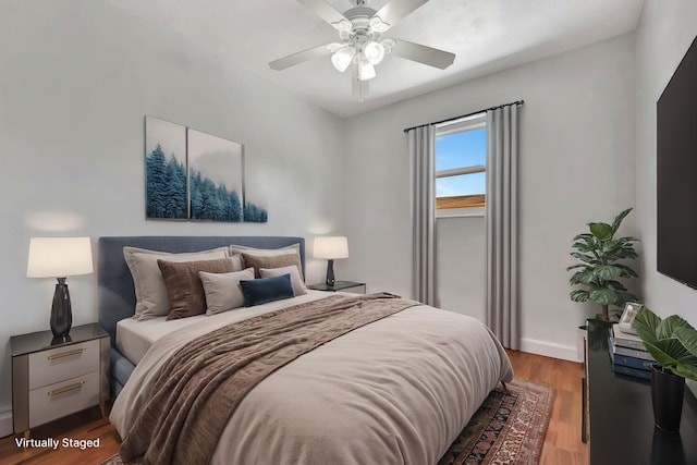 bedroom with a ceiling fan, wood finished floors, and baseboards
