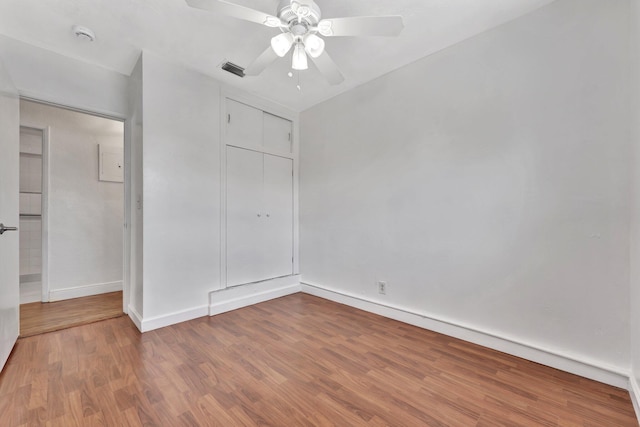 unfurnished bedroom with visible vents, a ceiling fan, wood finished floors, a closet, and baseboards