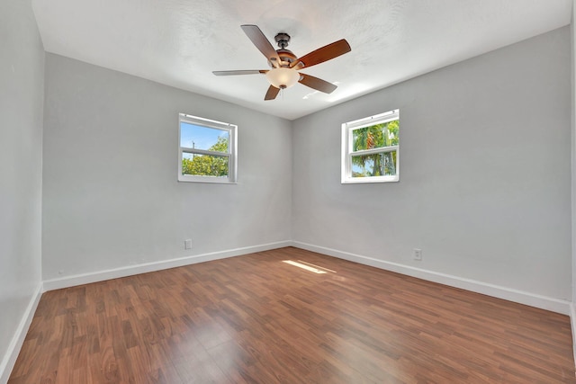 empty room with ceiling fan, baseboards, and wood finished floors
