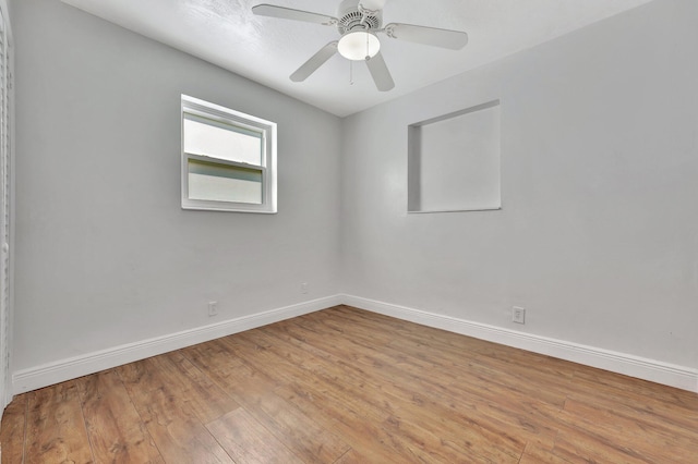 empty room featuring hardwood / wood-style floors, baseboards, and ceiling fan