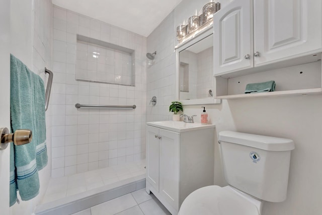bathroom with tile patterned floors, toilet, vanity, and a tile shower