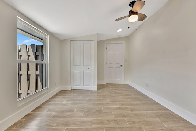 spare room with vaulted ceiling, a ceiling fan, baseboards, and wood tiled floor