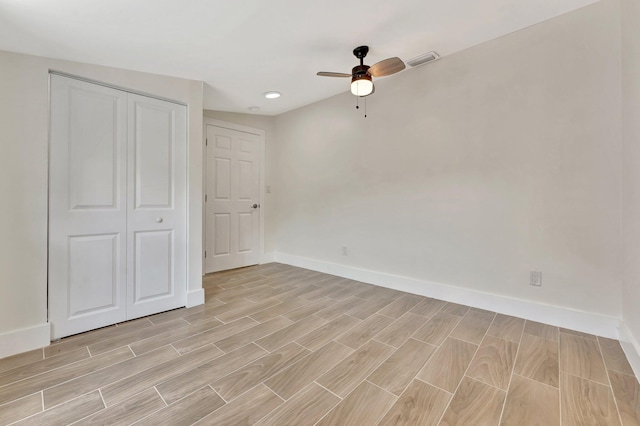 unfurnished bedroom featuring visible vents, baseboards, a closet, and wood finish floors