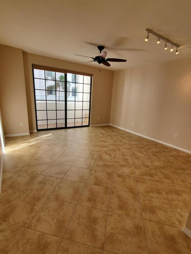 unfurnished room with light tile patterned floors, track lighting, baseboards, and a ceiling fan