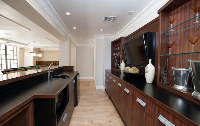 bar featuring visible vents, dishwasher, crown molding, light wood-style floors, and a sink