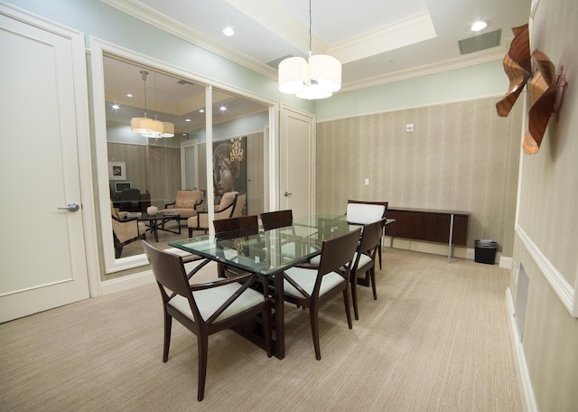 dining room with ornamental molding, a raised ceiling, visible vents, and light carpet