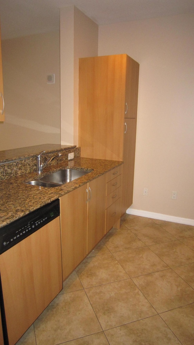 kitchen featuring a sink, light tile patterned floors, dark stone countertops, and dishwasher