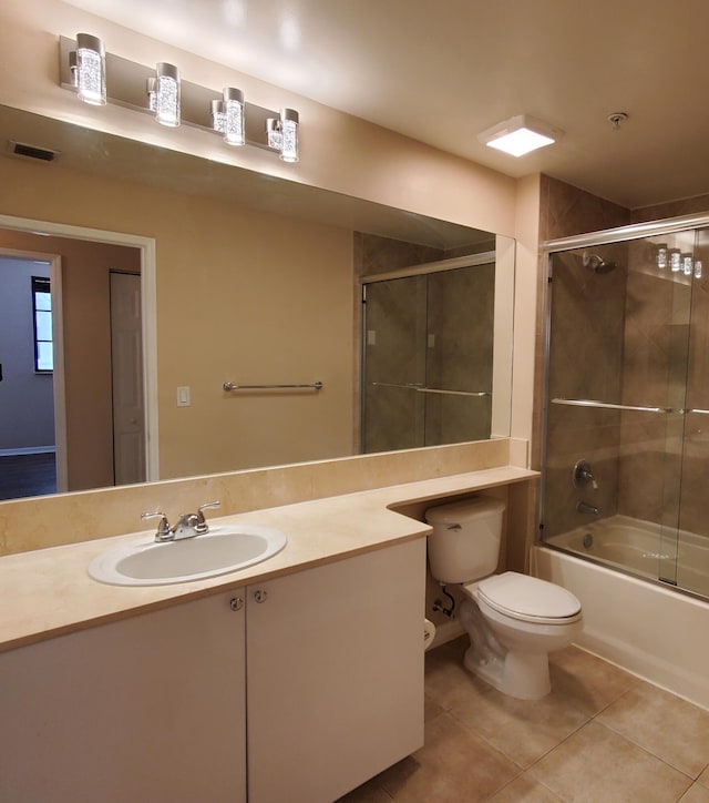 full bathroom featuring visible vents, toilet, tile patterned floors, combined bath / shower with glass door, and vanity