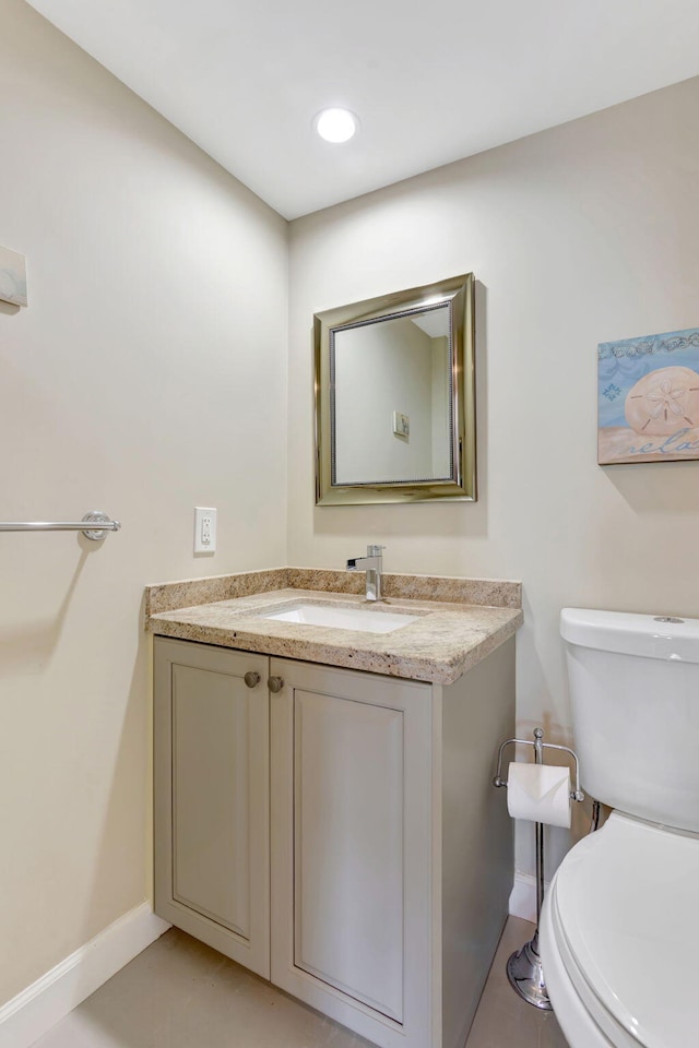 half bath with recessed lighting, baseboards, toilet, and vanity