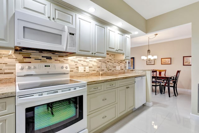 kitchen featuring baseboards, decorative light fixtures, decorative backsplash, white appliances, and a sink