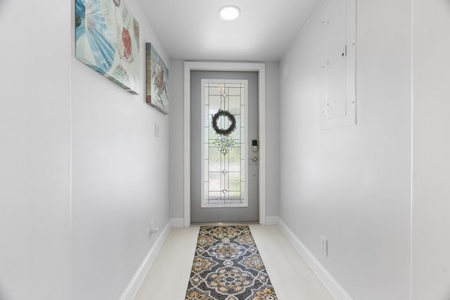 doorway with electric panel and baseboards