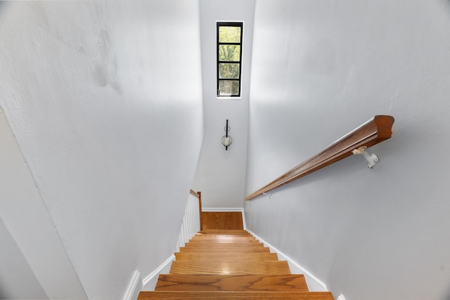 stairway featuring baseboards and wood finished floors