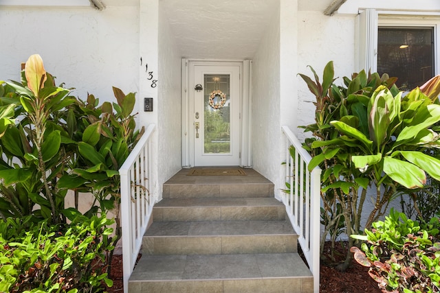 entrance to property featuring stucco siding