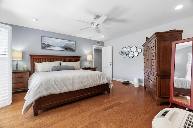 bedroom featuring a ceiling fan, visible vents, wood finished floors, baseboards, and recessed lighting