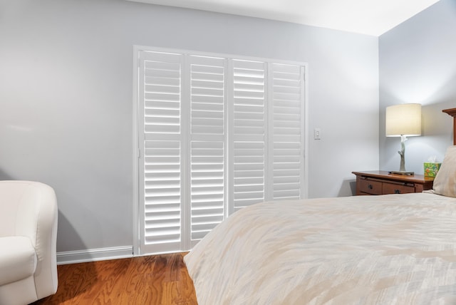 bedroom with wood finished floors and baseboards