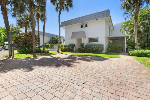 view of front of home featuring a sunroom and stucco siding