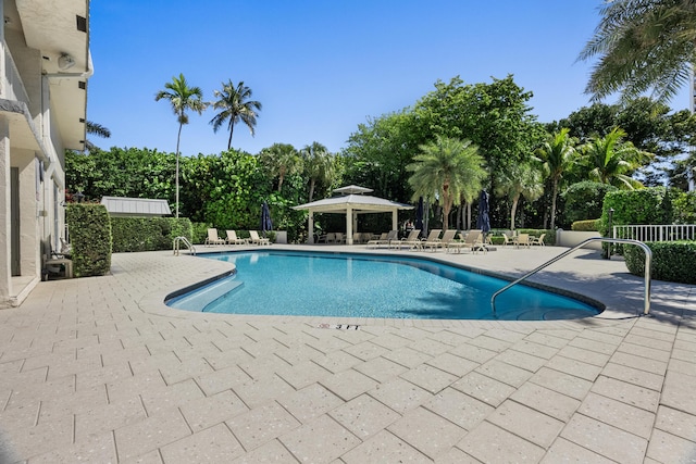 community pool with a gazebo, a patio area, and fence