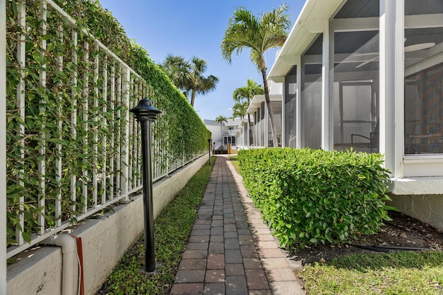 view of side of property featuring fence and a sunroom