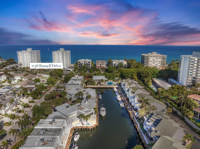 aerial view at dusk with a city view and a water view