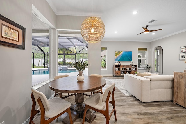 dining area featuring visible vents, recessed lighting, light wood-style floors, crown molding, and a sunroom