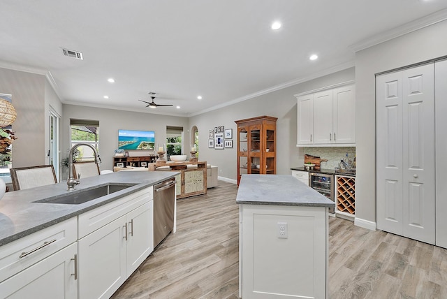 kitchen featuring visible vents, dishwasher, decorative backsplash, arched walkways, and a sink