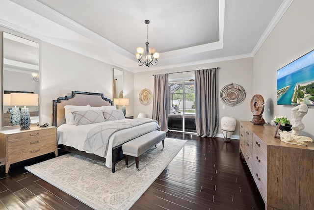 bedroom with a tray ceiling, ornamental molding, dark wood-style flooring, an inviting chandelier, and access to outside