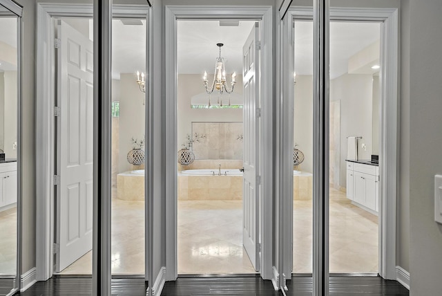 full bath featuring a bath and a chandelier