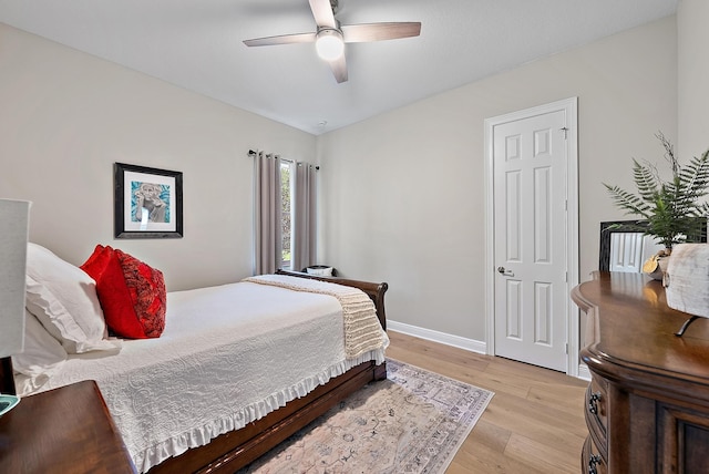 bedroom with light wood-style flooring, baseboards, and ceiling fan