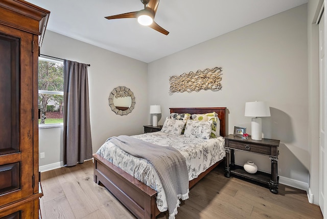 bedroom with baseboards, ceiling fan, and light wood finished floors