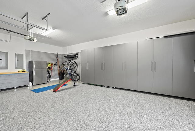 exercise area featuring electric panel, a garage, and a textured ceiling