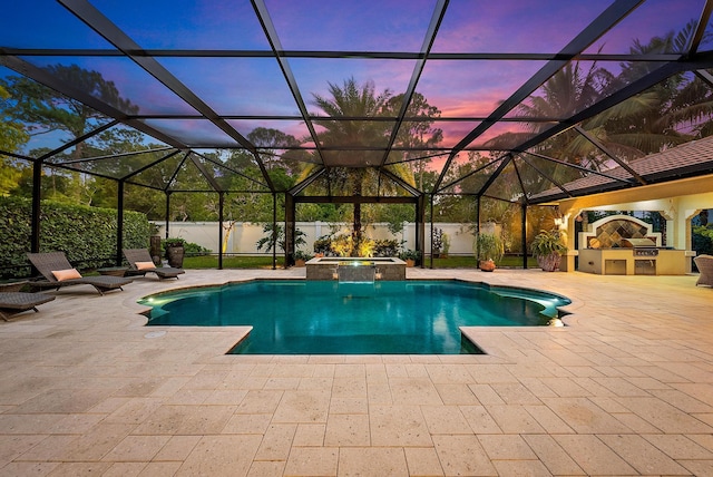 pool at dusk featuring a fenced backyard, a patio, exterior kitchen, and a pool with connected hot tub