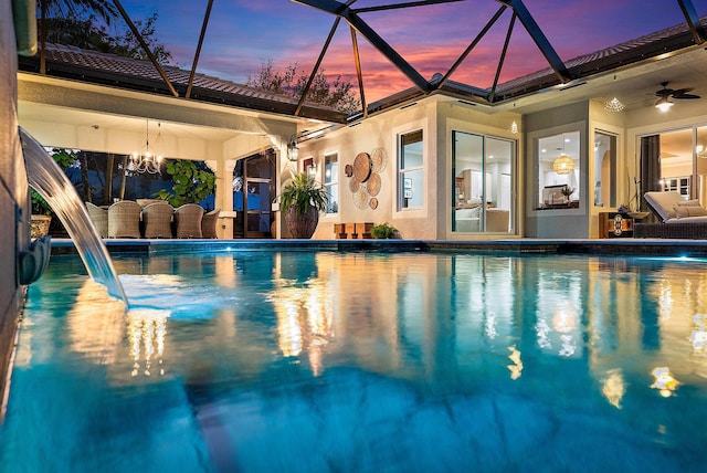 outdoor pool with a lanai, a ceiling fan, and a patio area