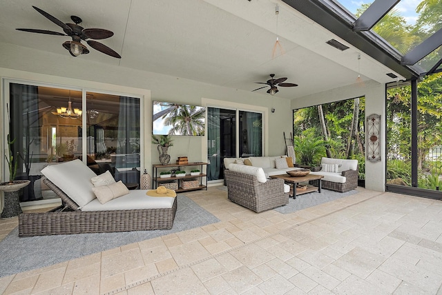 view of patio featuring glass enclosure, ceiling fan, visible vents, and an outdoor hangout area