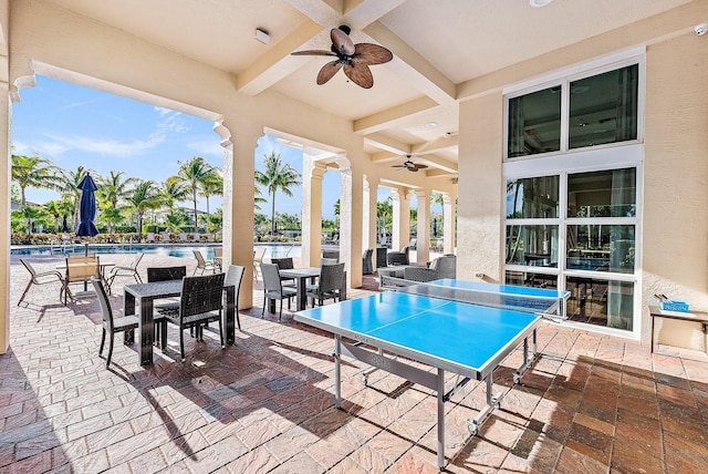 view of patio / terrace featuring outdoor dining area, a community pool, and a ceiling fan