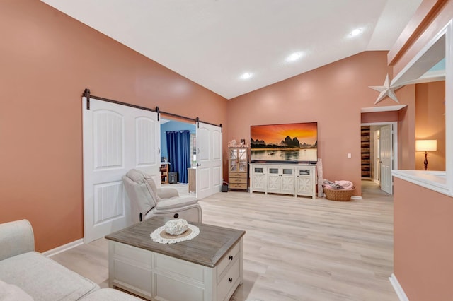 living room featuring baseboards, lofted ceiling, recessed lighting, light wood-style floors, and a barn door