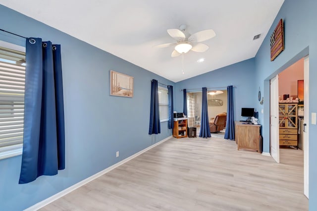 interior space featuring light wood finished floors, visible vents, ceiling fan, baseboards, and vaulted ceiling