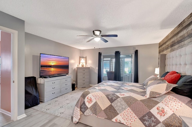 bedroom featuring a textured ceiling, ceiling fan, and wood finished floors