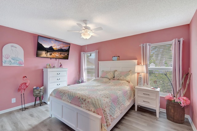 bedroom with baseboards, a textured ceiling, a ceiling fan, and light wood finished floors