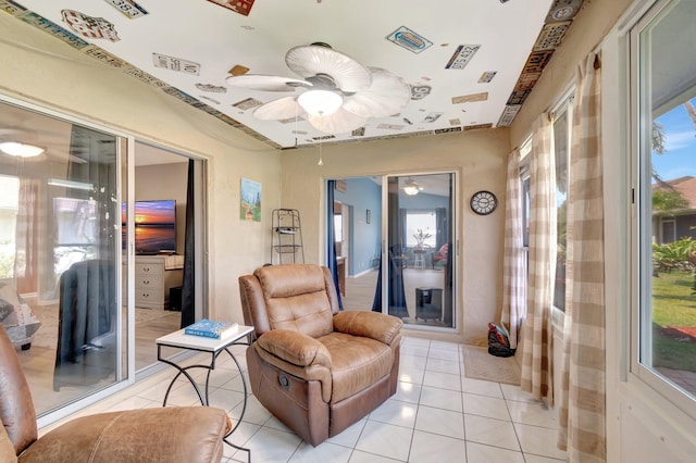 living area featuring light tile patterned flooring, a ceiling fan, and visible vents