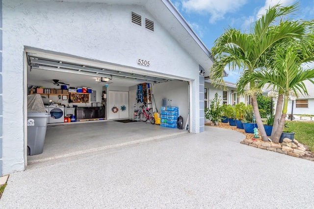 garage with washer and dryer, a garage door opener, and driveway