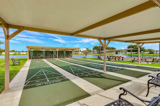 view of home's community featuring shuffleboard, a lawn, and a water view