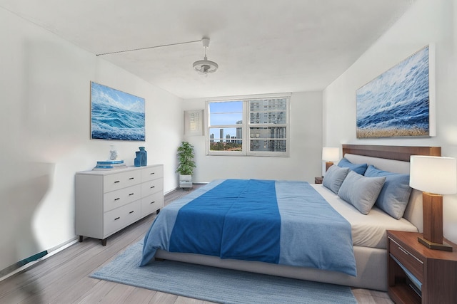 bedroom featuring baseboards and wood finished floors