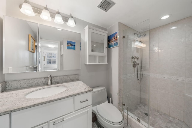 full bathroom featuring visible vents, a stall shower, toilet, and vanity