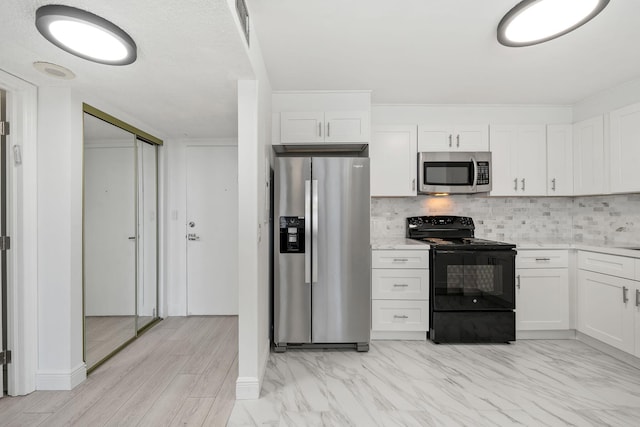 kitchen featuring white cabinetry, visible vents, backsplash, and stainless steel appliances