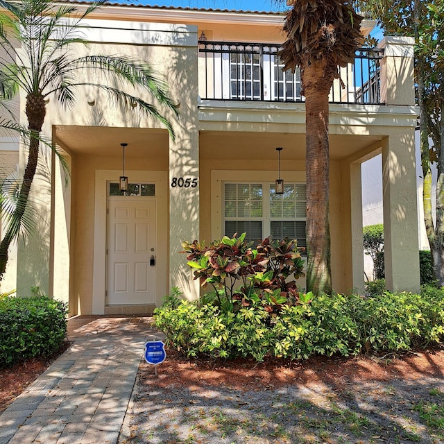 entrance to property featuring stucco siding and a balcony